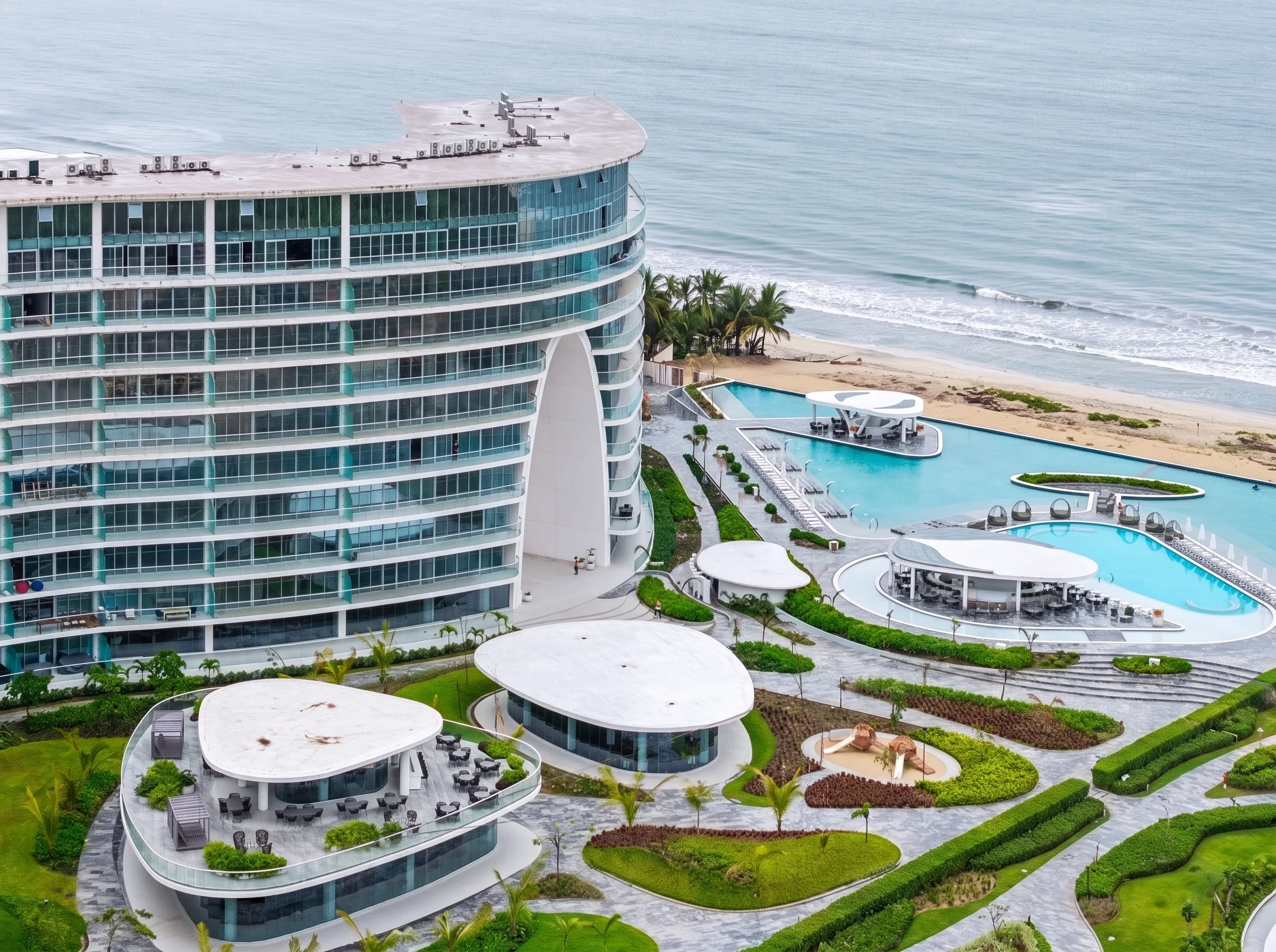 Vista aérea de Amancay frente al mar: edificio, albercas y playa en Flamingos, Nuevo Vallarta